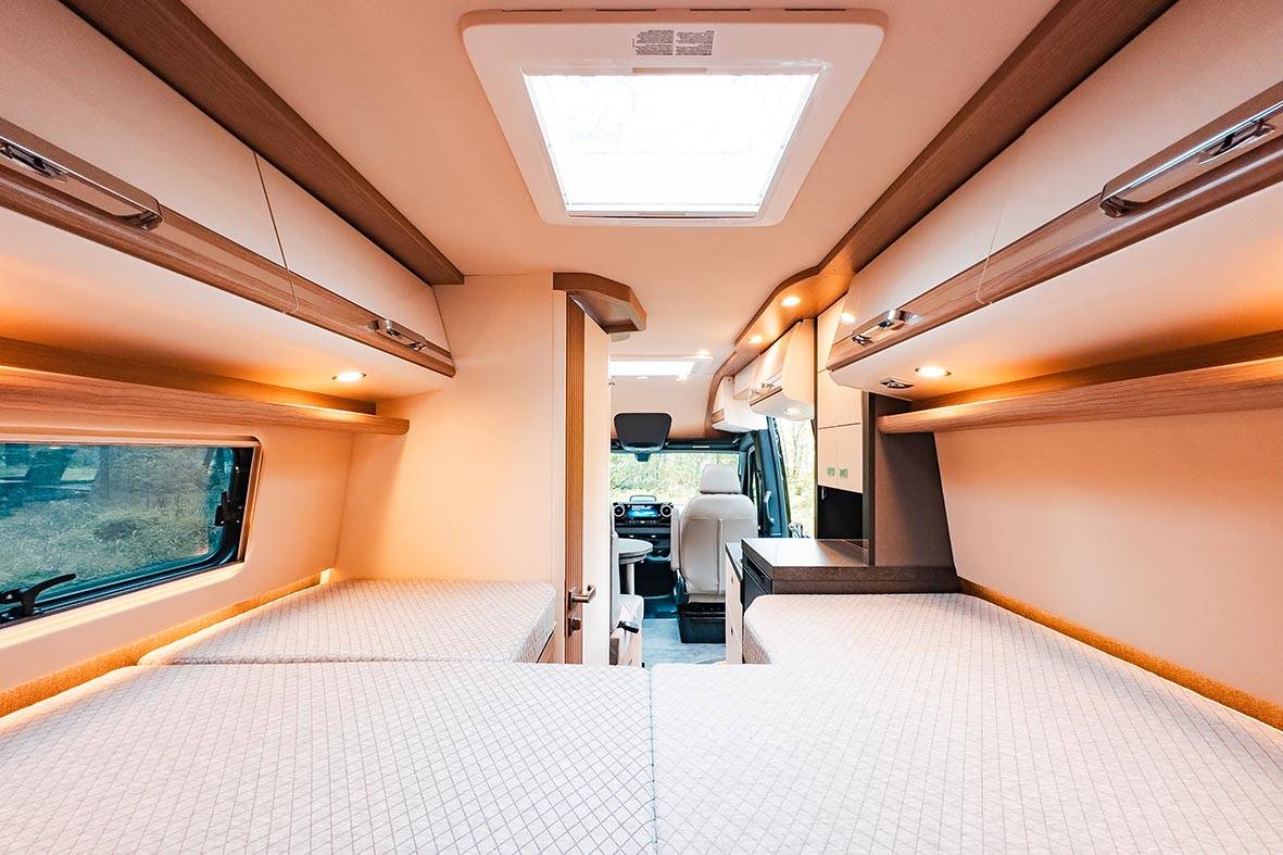 Blick von den Längsbetten im Malibu Genius 4x4 nach vorn in Richtung Wohnbereich und Fahrerhaus.