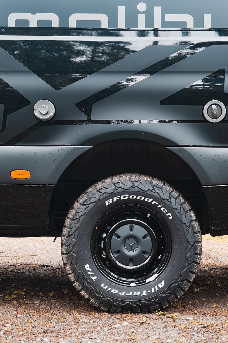 Malibu Genius 4x4 mit BFGoodrich All-Terrain-Bereifung und schwarzer Stahlfelge in Detailansicht.