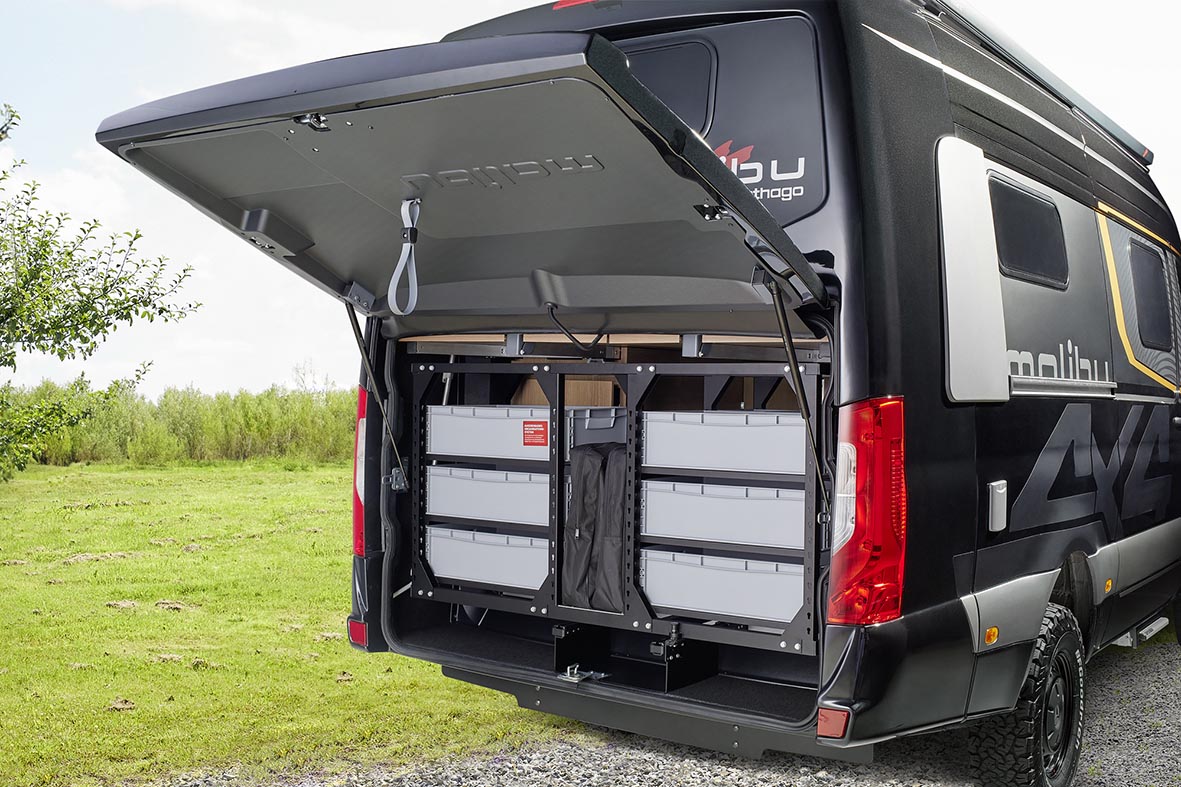 Geöffnete Heckgarage des Malibu Genius 4x4 mit eingebautem Organisationssystem und Stauboxen.