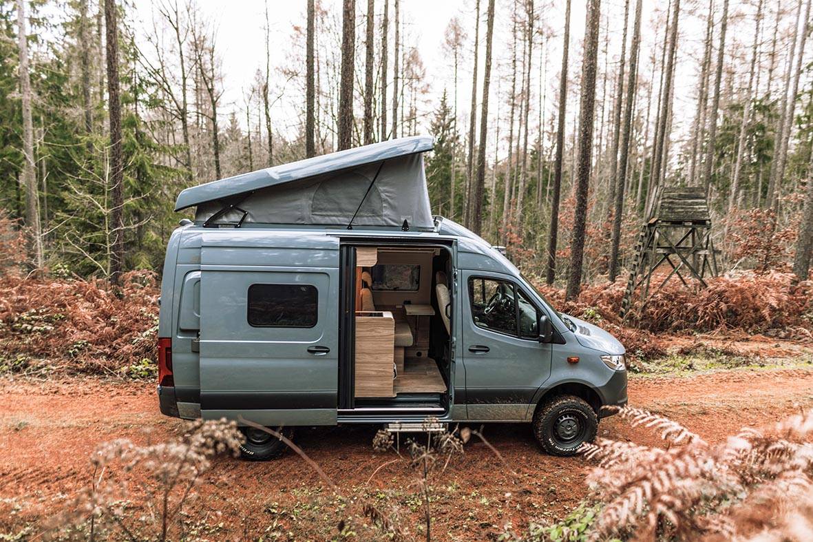 Hymer Grand Canyon S steht im Wald mit geöffnetem Klapp-Schlafdach